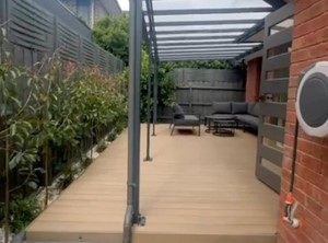 הקמת גינה הכוללת פרגולת אלומיניום דק דמוי עץ צמחייה משטח חצץ ואבני מדרך